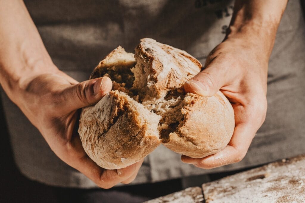 Hands breaking apart bread to share